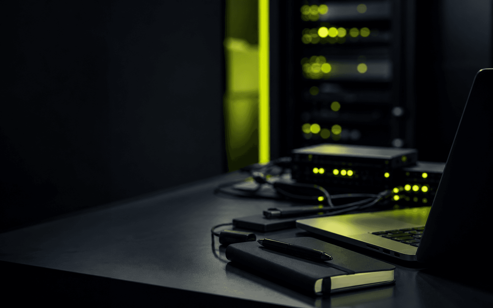 Dark operations desk with network hardware and WRLDWIDE green lighting
